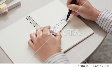 単語を覚えるアジア人男性の手元 132147996