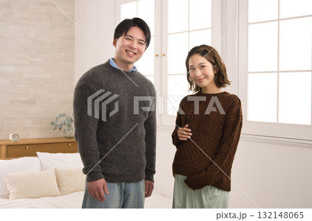 窓際に立つ若い夫婦　妊婦さん 132148065