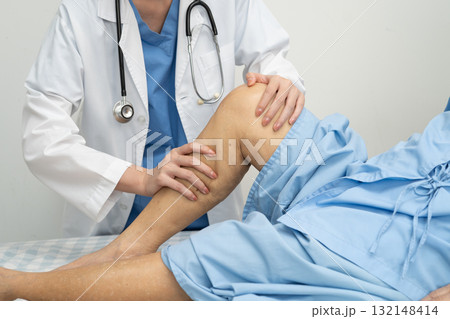 Doctor checking Asian elderly woman patient with scar knee replacement surgery in hospital. 132148414