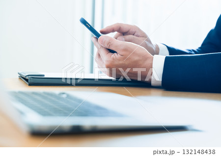 スマホを操作するビジネスマンの手元 132148438