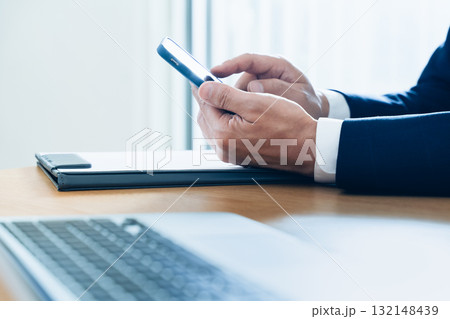 スマホを操作するビジネスマンの手元 132148439