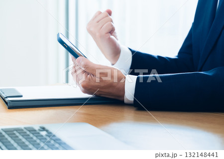 スマホを操作するビジネスマンの手元 スマホを操作するビジネスマンの手元 132148441