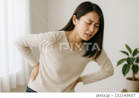 腰に手を当ててつらそうな表情をする人 腰に手を当ててつらそうな表情をする人 132148687