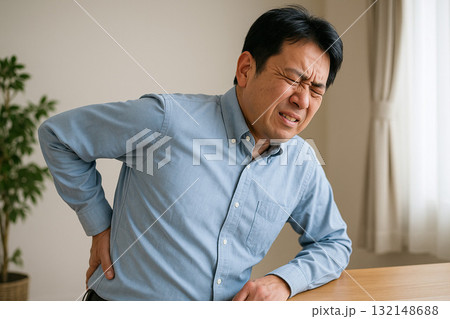 腰に手を当ててつらそうな表情をする人 132148688