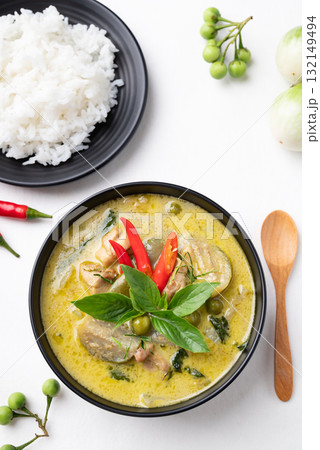 Thai green curry chicken with rice and ingredients on white background 132149494