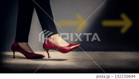 Woman stepping forward along a yellow arrow on asphalt 132150694