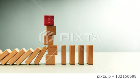 Red wooden block with exclamation mark standing among dominoes Red wooden block with exclamation mark standing among dominoes 132150699