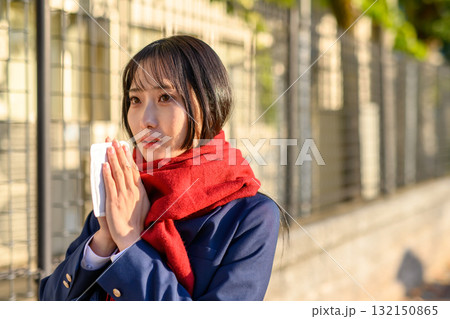 寒い日に登下校する女子高生　冬服でカイロを持ち通学する高校生　ブレザー　登校下校 132150865