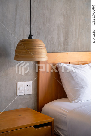 Cozy bedroom detail with wooden lampshade and concrete wall. Cozy bedroom detail with wooden lampshade and concrete wall. 132150964