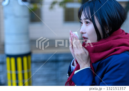 寒い日に登下校する女子高生　冬服でカイロを持ち通学する高校生　ブレザー　登校下校 132151357