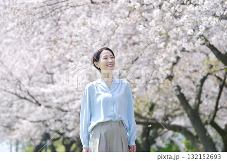 満開の桜と散歩する女性 132152693