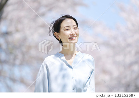 満開の桜と散歩する女性 132152697
