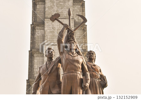 A statue with three people holding the hammer, sickle and caligraphy brush of North Korea 132152909
