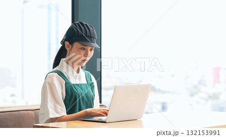 ノートパソコンでデータ入力する飲食店店員 132153991