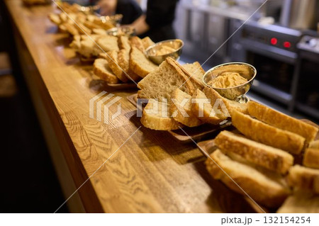 A beautifully arranged Assorted Bread Platter featuring a variety of Spreads on a Wooden Countertop A beautifully arranged Assorted Bread Platter featuring a variety of Spreads on a Wooden Countertop 132154254
