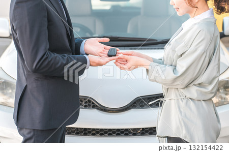 女性客から車の鍵を預かる営業マン,セールスマンの男性スタッフ 132154422