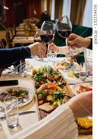 Cheers to a Fantastic Celebration Friends Joyfully Toasting with Wine Glasses in Hand 132154439