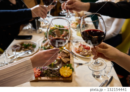 Cheers to a Fantastic Celebration Friends Joyfully Toasting with Wine Glasses in Hand Cheers to a Fantastic Celebration Friends Joyfully Toasting with Wine Glasses in Hand 132154441