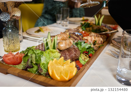 Indulge in an exquisite gourmet platter perfectly paired with a fine red wine selection 132154480