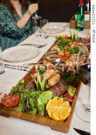 Indulge in an exquisite gourmet platter perfectly paired with a fine red wine selection 132154494