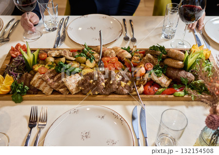 Indulge in an exquisite gourmet platter perfectly paired with a fine red wine selection 132154508