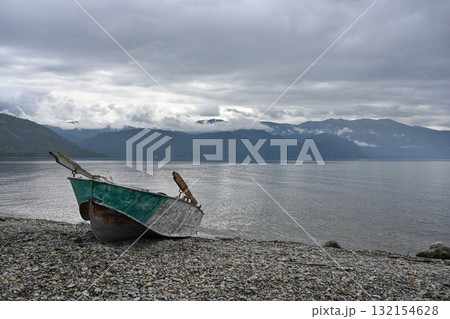 Delightful landscape with a rowing boat on the shore of a mountain lake 132154628