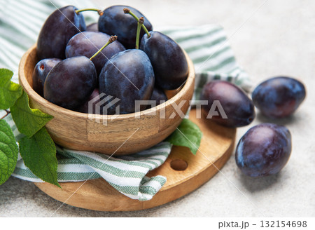 Fresh ripe plums filling a wooden bowl Fresh ripe plums filling a wooden bowl 132154698