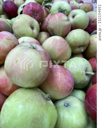 Fresh apples in various shades of green and red, piled closely together as a colorful background Fresh apples in various shades of green and red, piled closely together as a colorful background 132154951