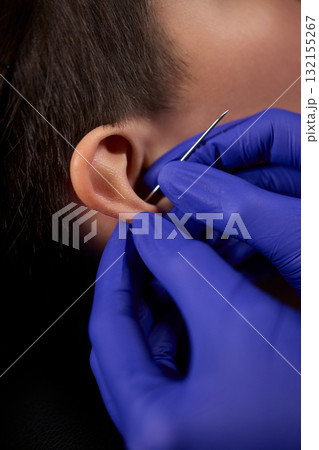 Professional Piercing Process A detailed closeup view showcasing the art of Ear Piercing Professional Piercing Process A detailed closeup view showcasing the art of Ear Piercing 132155267