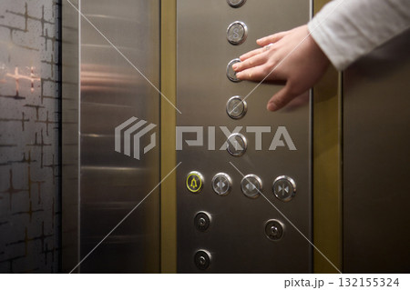 Pressing the elevator button in contemporary high rise buildings signifies modern urban convenience 132155324