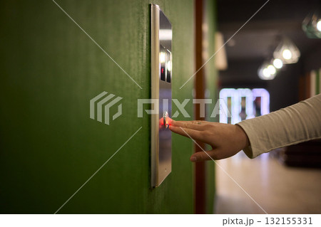 Pressing the elevator button in contemporary high rise buildings signifies modern urban convenience 132155331
