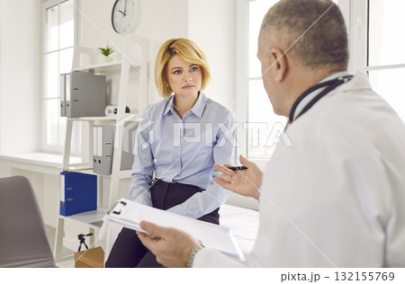 Mature male doctor consulting female patient in medical office 132155769