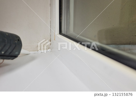 Sealing the corners of windows with caulk for achieving a perfectly neat and polished finish Sealing the corners of windows with caulk for achieving a perfectly neat and polished finish 132155876