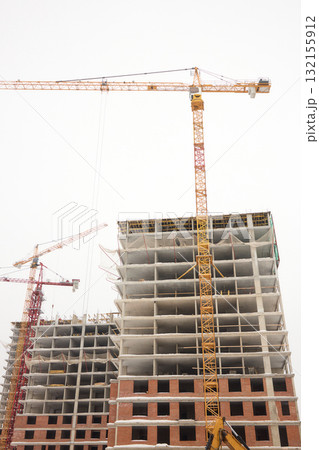 A bustling Construction Site showcasing Cranes, Building Framework, and full activity all around 132155912