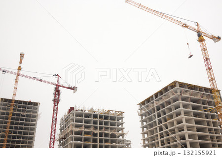 A bustling Construction Site showcasing Cranes, Building Framework, and full activity all around A bustling Construction Site showcasing Cranes, Building Framework, and full activity all around 132155921