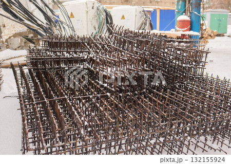 A construction site with piles of organized reinforced steel bars being prepared for use 132155924