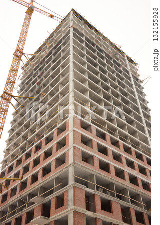 A bustling Construction Site showcasing Cranes, Building Framework, and full activity all around 132155928