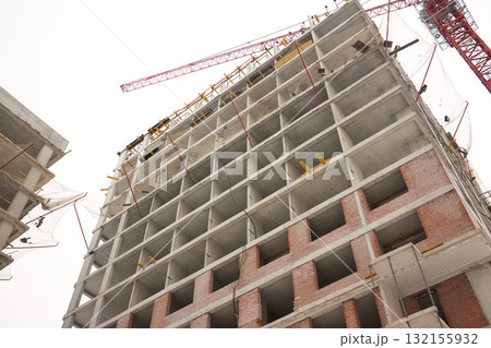 A bustling Construction Site showcasing Cranes, Building Framework, and full activity all around A bustling Construction Site showcasing Cranes, Building Framework, and full activity all around 132155932