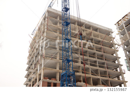 A bustling Construction Site showcasing Cranes, Building Framework, and full activity all around A bustling Construction Site showcasing Cranes, Building Framework, and full activity all around 132155987