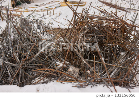 A construction site with piles of organized reinforced steel bars being prepared for use 132156050