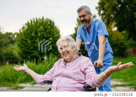 Senior patient and male nurse talking during walk outdoors. 132156118