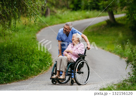 Male home nurse taking care of elderly woman in wheelchair. Male home nurse taking care of elderly woman in wheelchair. 132156120