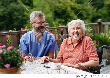 Nurse helping elderly woman measure blood sugar with glucometer. Nurse helping elderly woman measure blood sugar with glucometer. 132156124