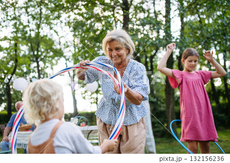 Family enjoying outdoor summer gathering with playful activities. 132156236