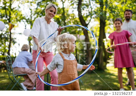 Family enjoying outdoor summer gathering with playful activities. 132156237