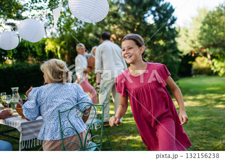 Family enjoying outdoor summer gathering with playful activities. 132156238