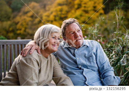 Peaceful moment for senior couple, enjoying warm autumn evening on terrace. Peaceful moment for senior couple, enjoying warm autumn evening on terrace. 132156295