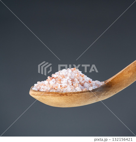 Heap of rose-colored sea salt on rustic wooden utensil, great for kitchen and mineral nutrition images 132156421