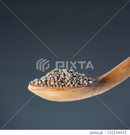 Dried coriander berries in natural wood spoon, ideal for seasoning, recipe preparation and kitchen concepts 132156425