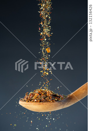 Aromatic spice mixture fall from above onto a wooden spoon, great for gourmet cooking and flavor enhancement themes. Aromatic spice mixture fall from above onto a wooden spoon, great for gourmet cooking and flavor enhancement themes. 132156426